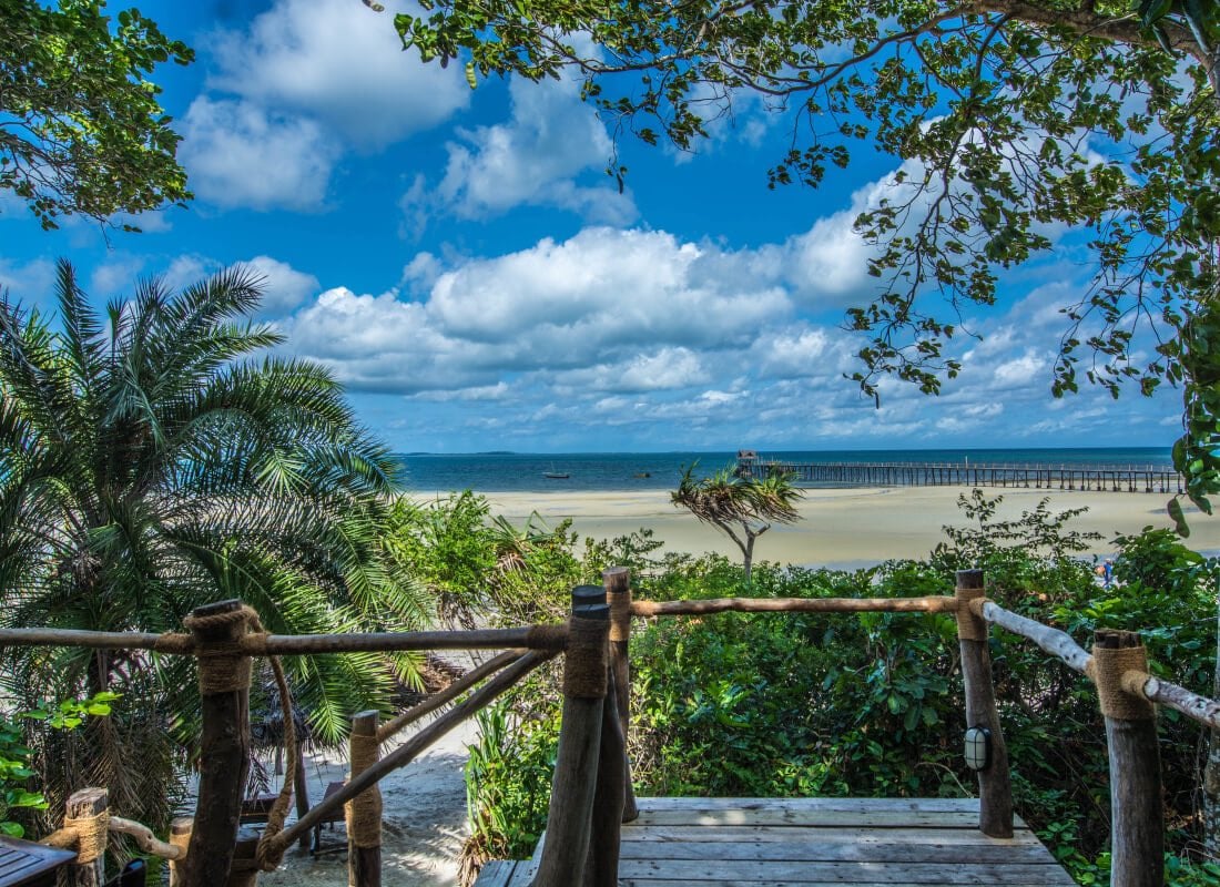 A wooden walkway leads to a glistening beach at Fundu Lagoon.