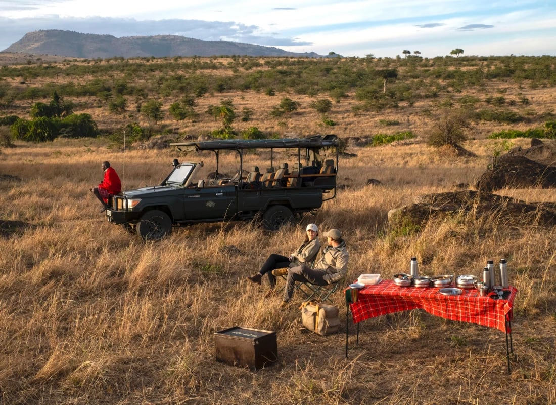A couple enjoy a midday picnic during a game drive.