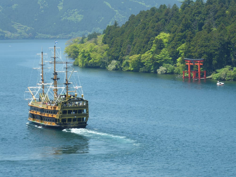 A pirate ship is sailing past Hakone's red Torii gates. 