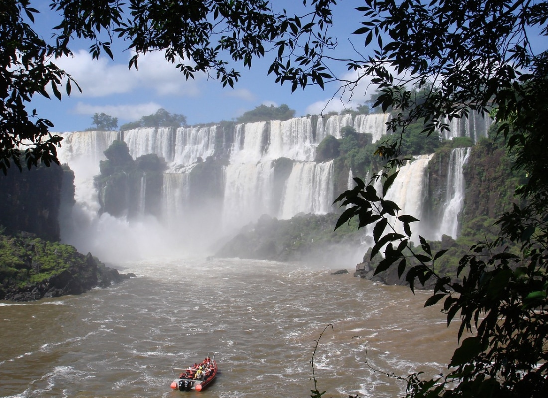 A small speed boat is approaching the thunderous water at Argentina's Iguazu Falls.