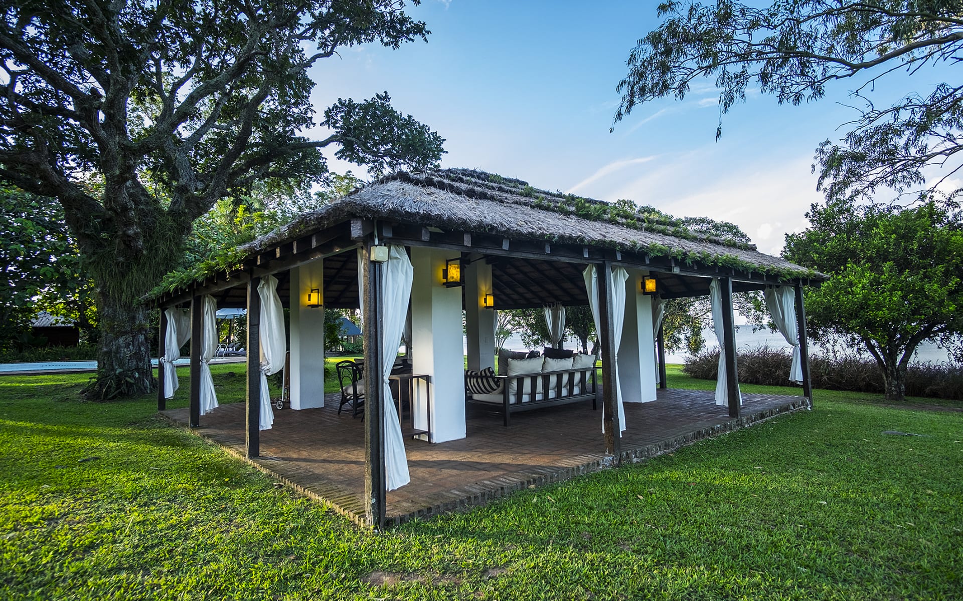 The common space at Hotel Puerto Valle is a beautiful thatched-roof open-plan gazebo with lanterns and sofas to relax in. 