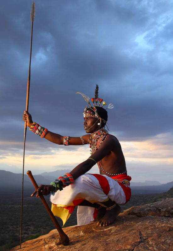 A Kenyan warrior sits on a rock in Saruni Samburu. 