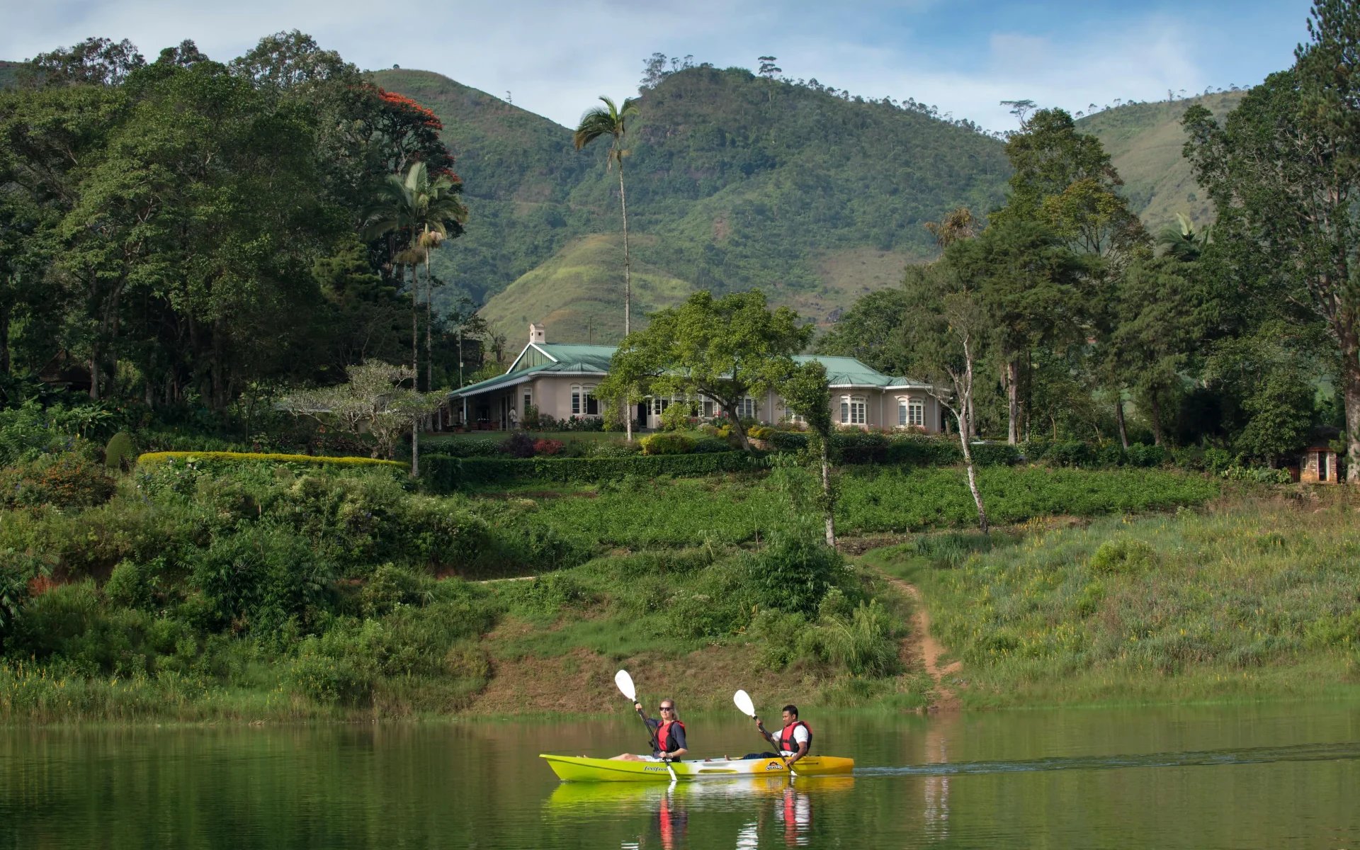 A couple is kayaking in the grounds of Ceylon Tea Trails. 