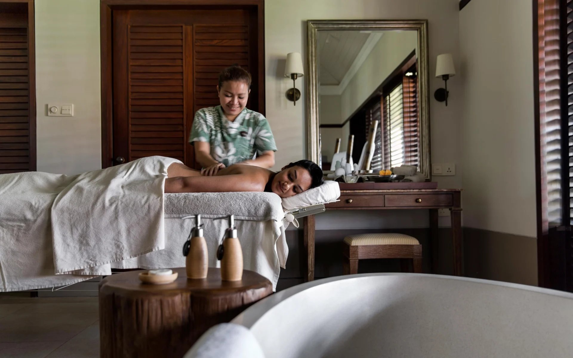 A woman is lying on a spa table having a massage. 