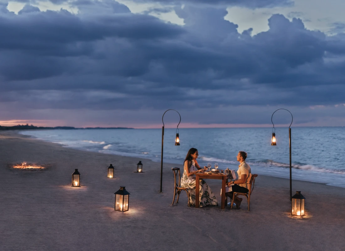 A couple is enjoying the private dining experience on the beach during Sri Lanka's sunset. 