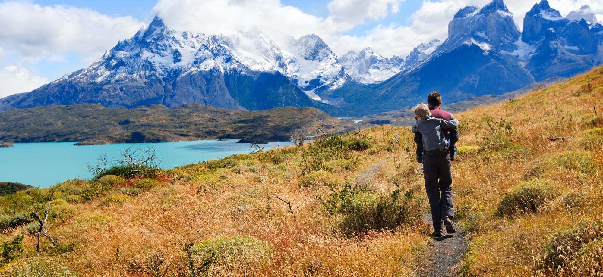 Family of two, father and son, enjoying hiking and active travel in Torres del Paine National Park.