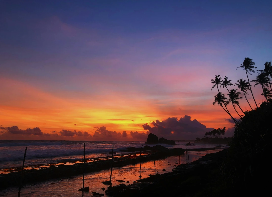 A red and orange sunset surrounds Colombo beach in Sri Lanka.