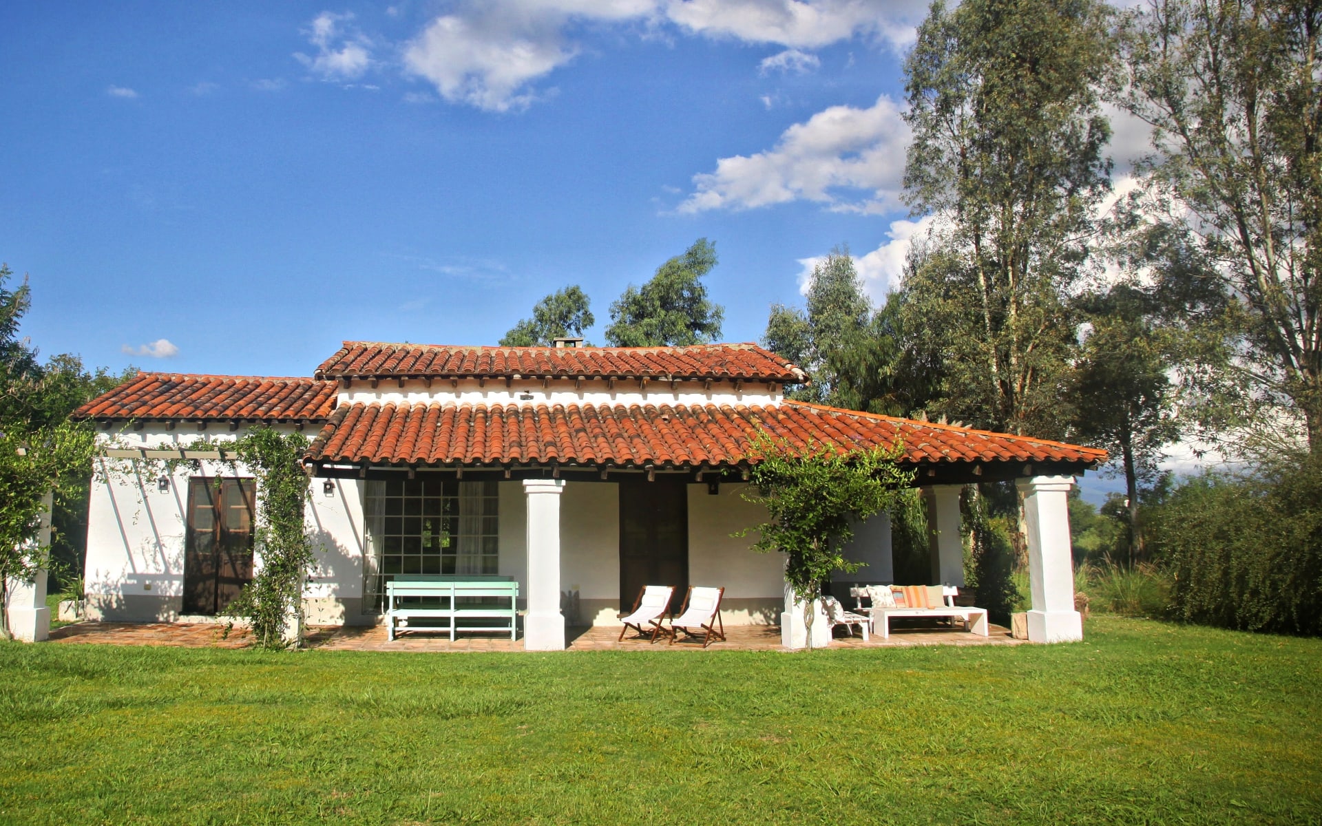 Finca Valentia in Argentina is a romantic-looking, white-washed building draped with plants and featuring red-tile roofs. 