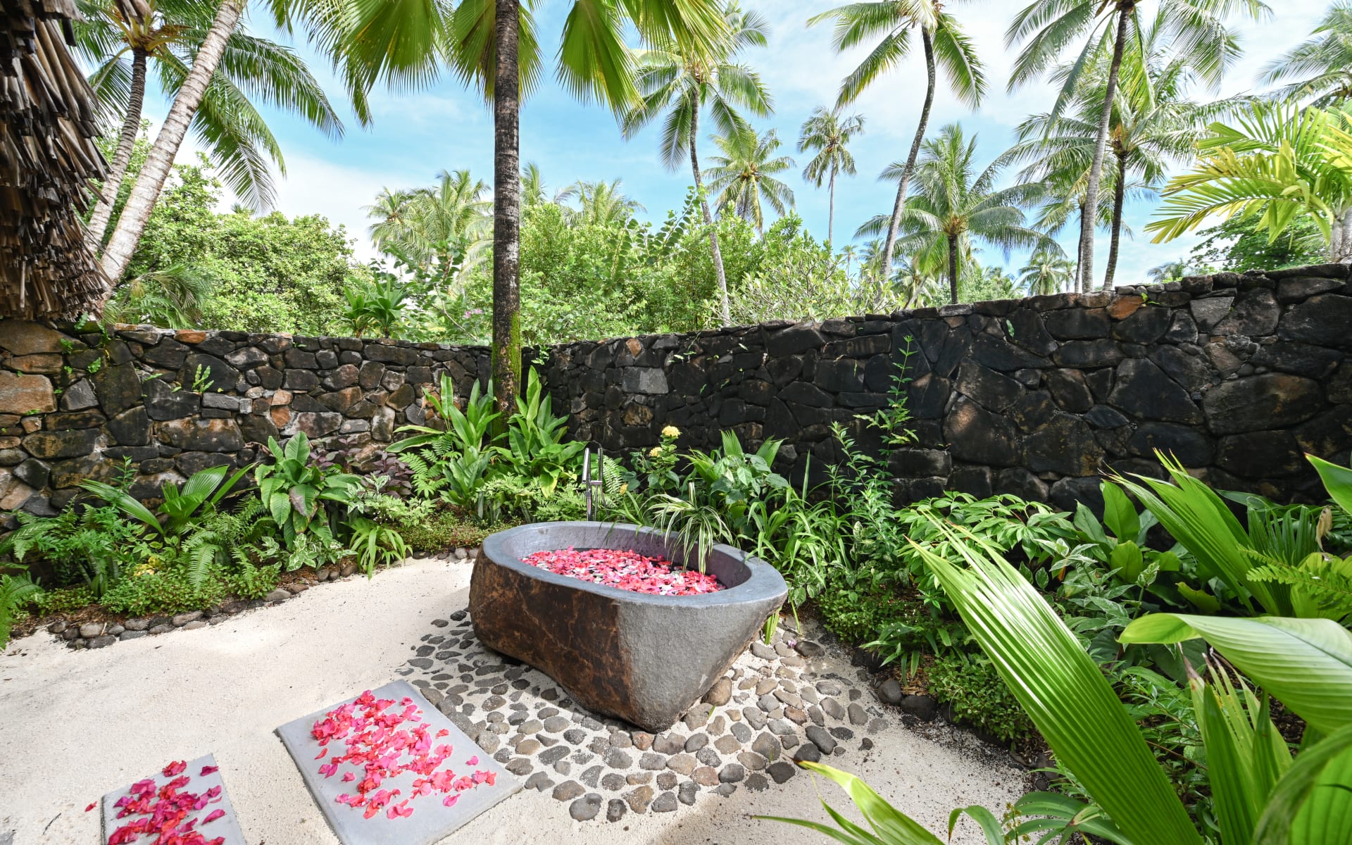 Romantic rose petalled topped private outside bath of a premium beachfront villa