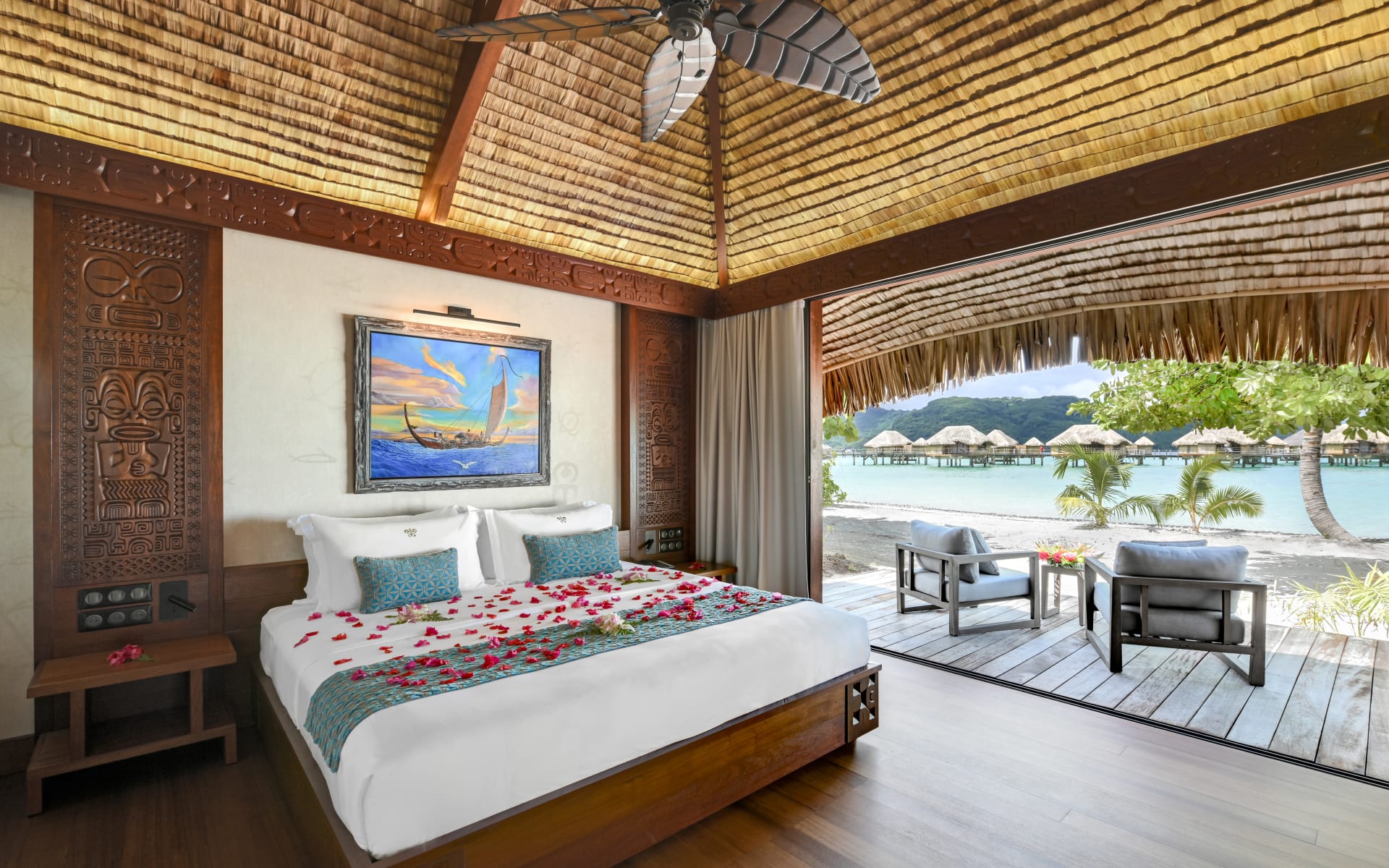 The rose-petalled bedroom area of a premium beachfront villa