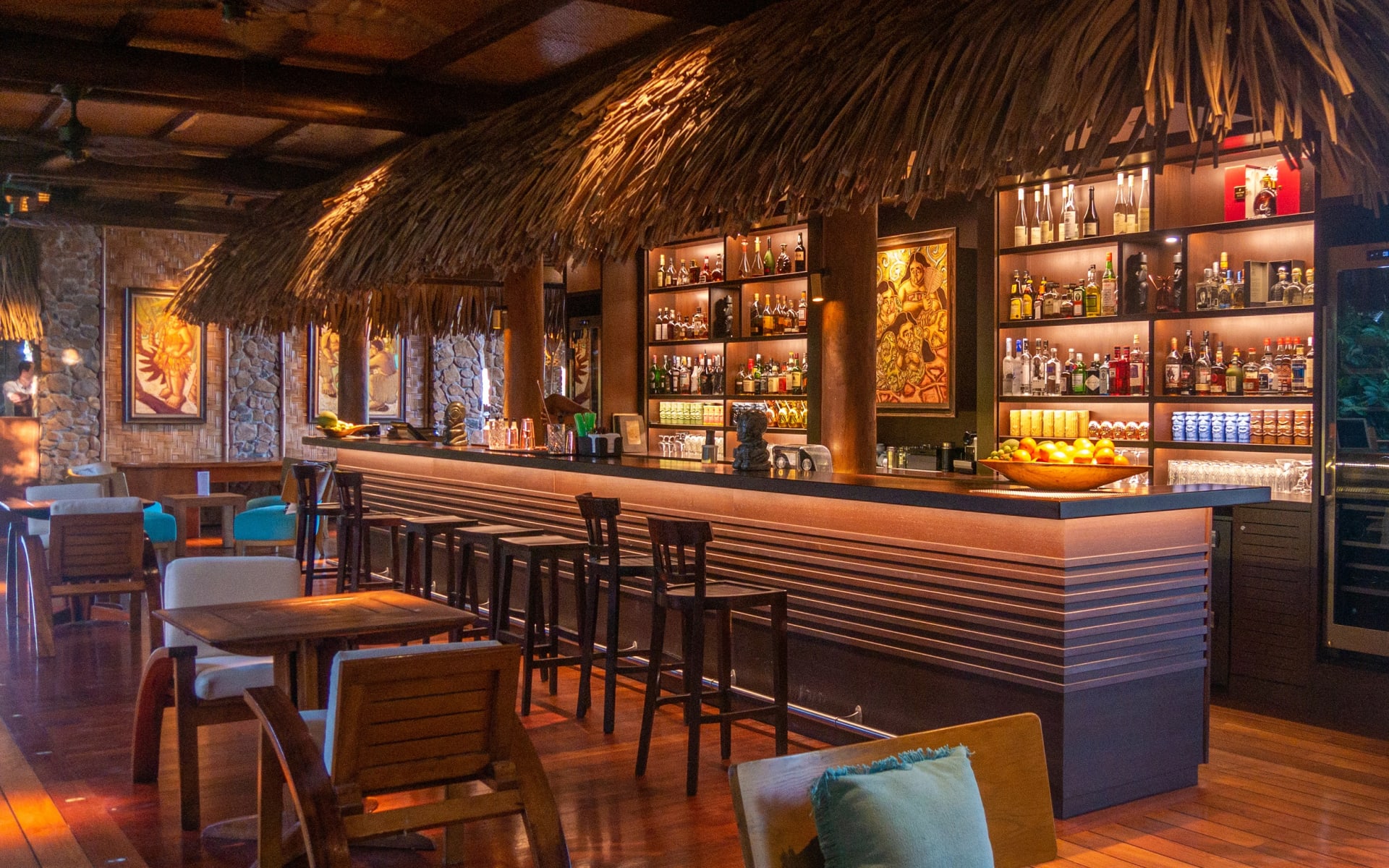 Gorgeous tiki bar with palm leaf canopy over bar area 