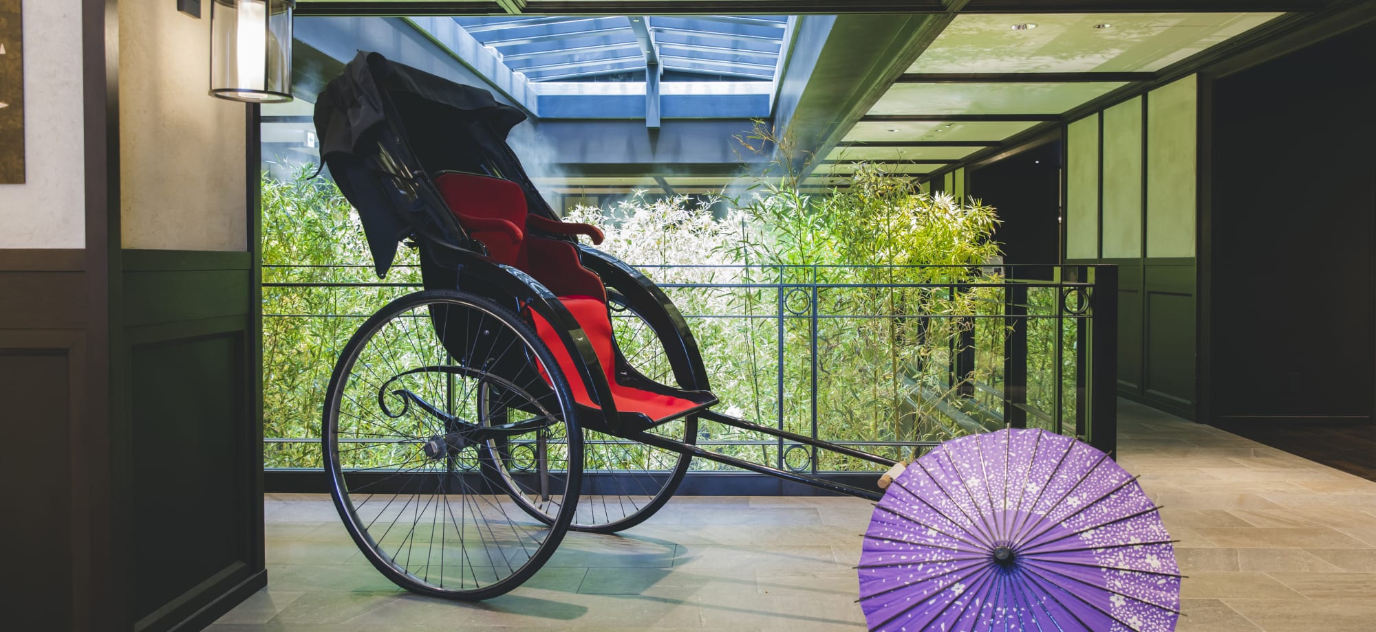 A carriage is situated in the corridor of Dhawa Yura and is next to a purple umbrella. 