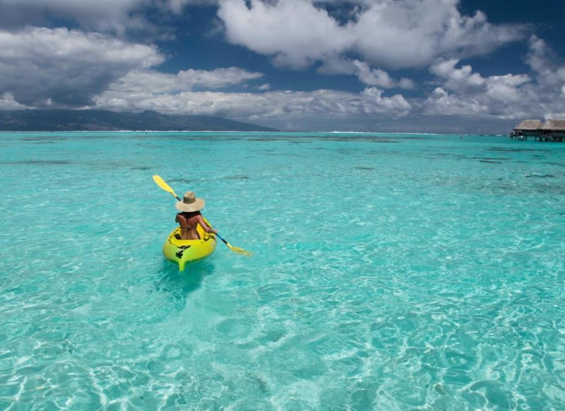 Lady kayaking in crystal clear ocean
