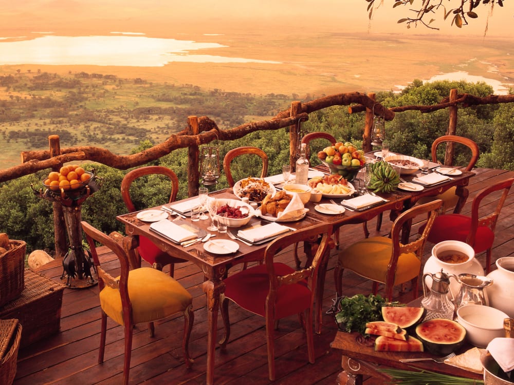 A dining table on a balcony looking over the countryside
