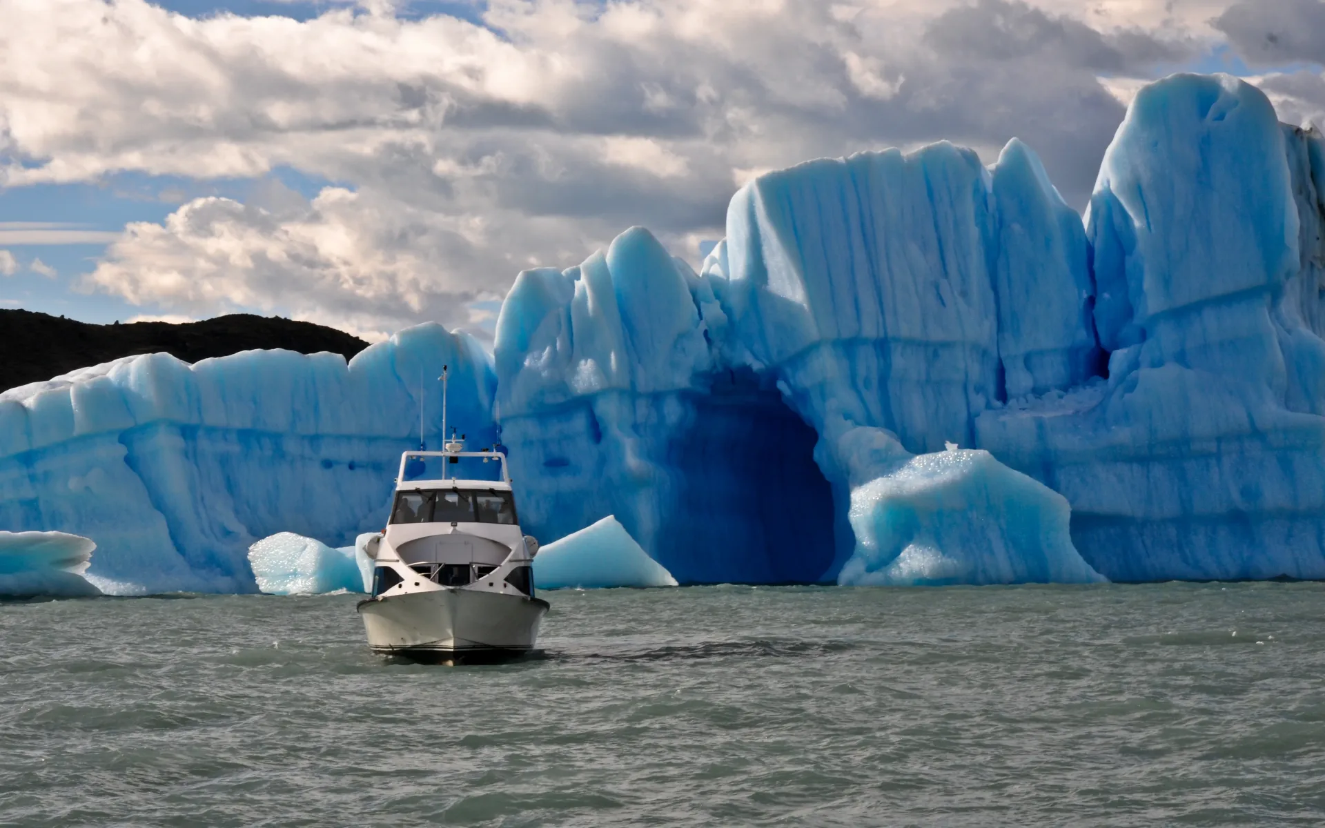 A sleek catamaran glides along Lago Argentino, past striking blue glaciers.