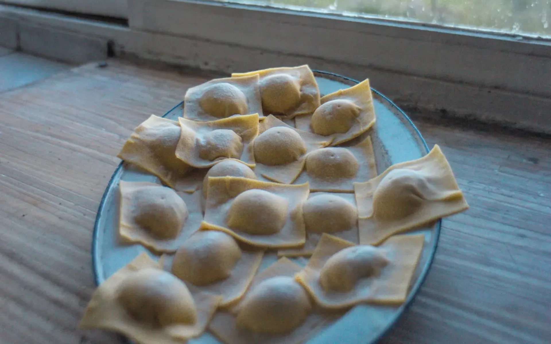 A delicious dish of freshly-made ravioli is laid out on a plate.