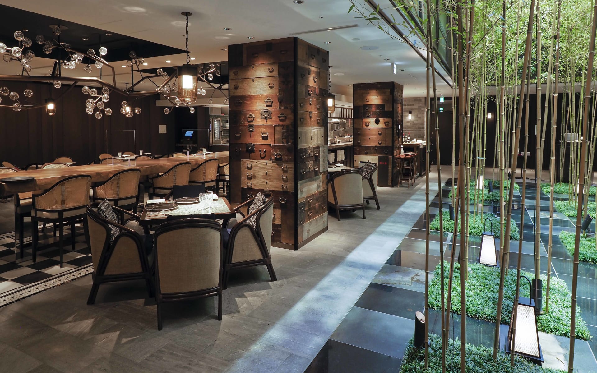 The restaurant at Dhawa Yura Hotel overlooks an indoor area with bamboo trees and greenery. 
