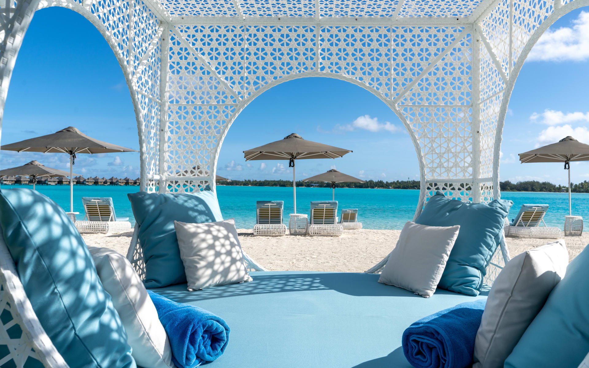 Lounge bed on sandy beach looking over blue ocean