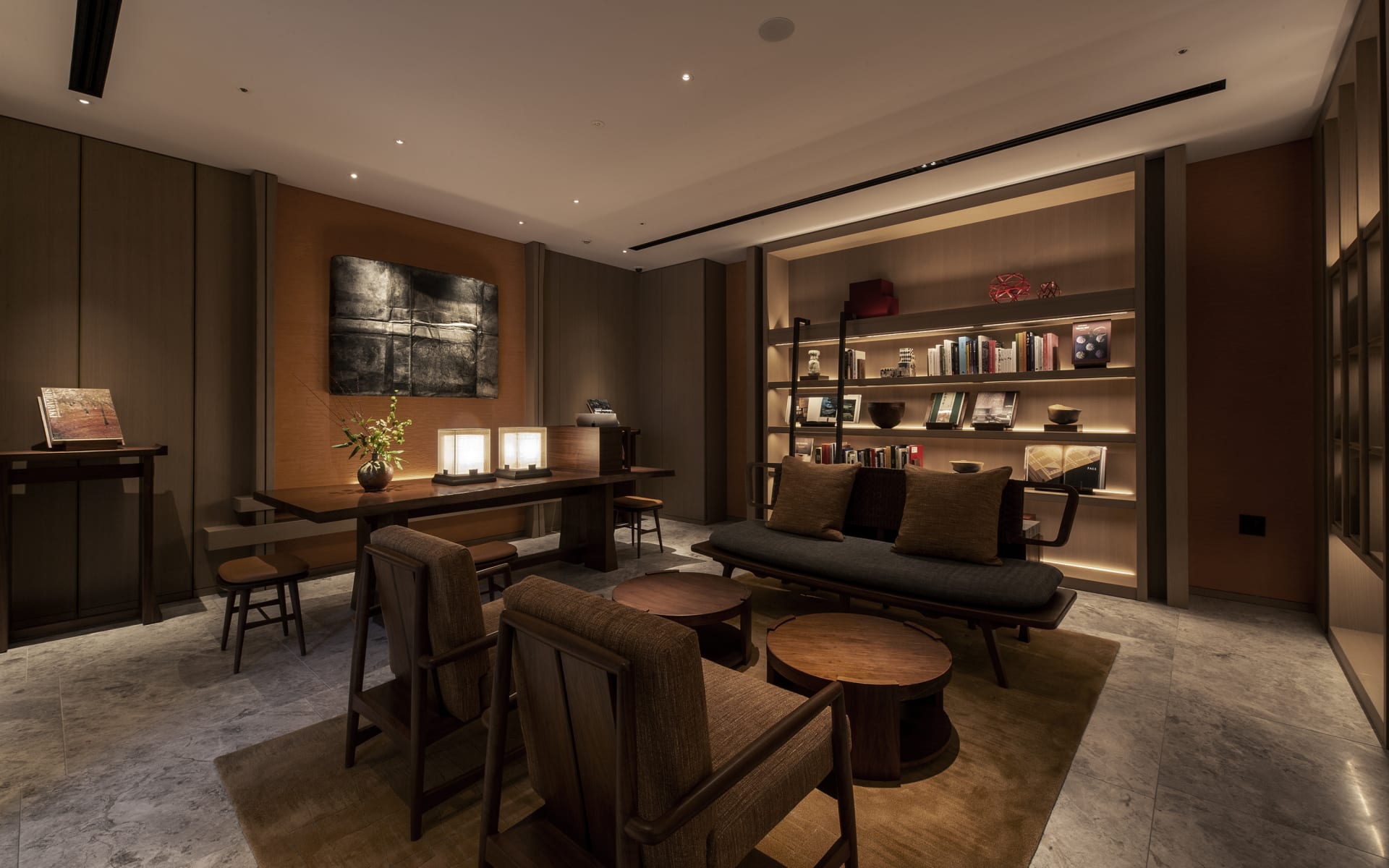 The library at The Mitsui Hotel has rows of books, low tables, arm chairs and sofas. 