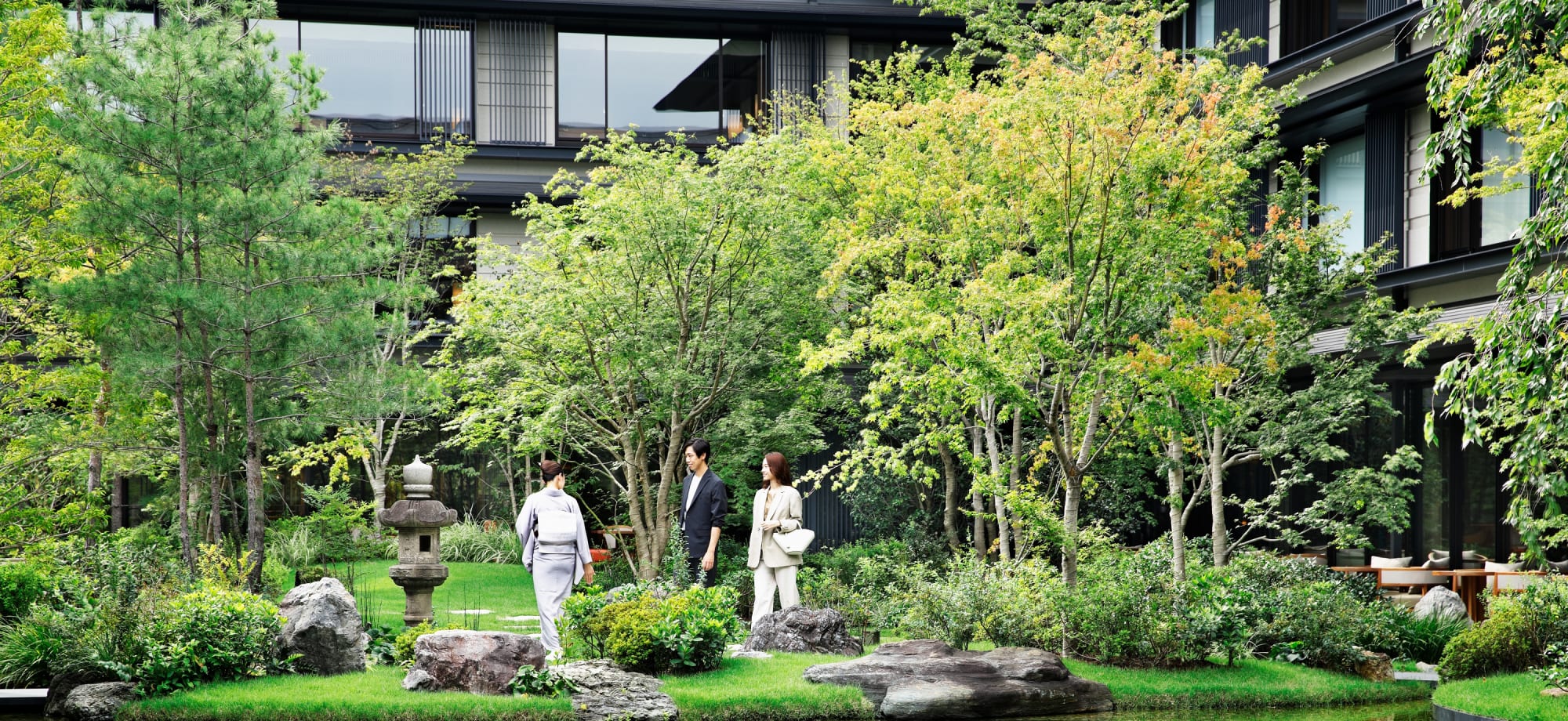 The Mitsui garden is surrounded by trees, rocks, water features and a pond. 