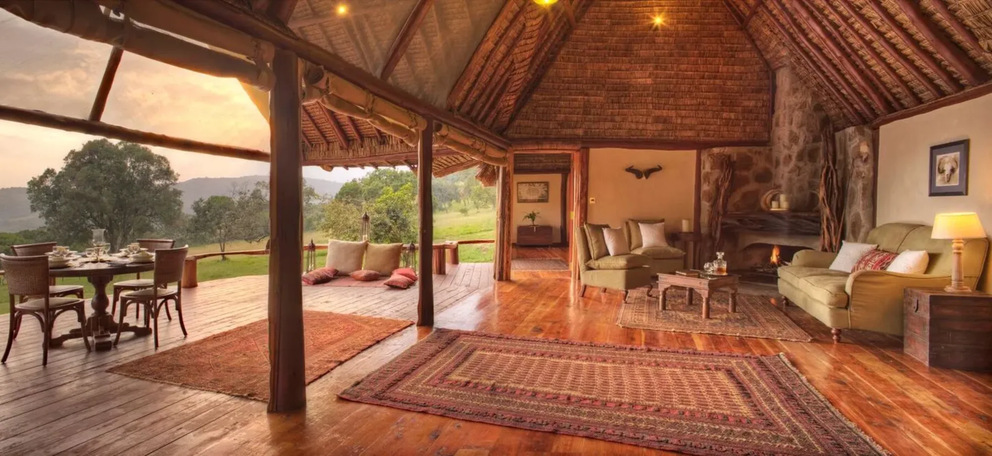 The Natural History Suite at Saruni Basecamp Mara has an indoor-outdoor plan with a viewing deck adorned with rugs and tables.