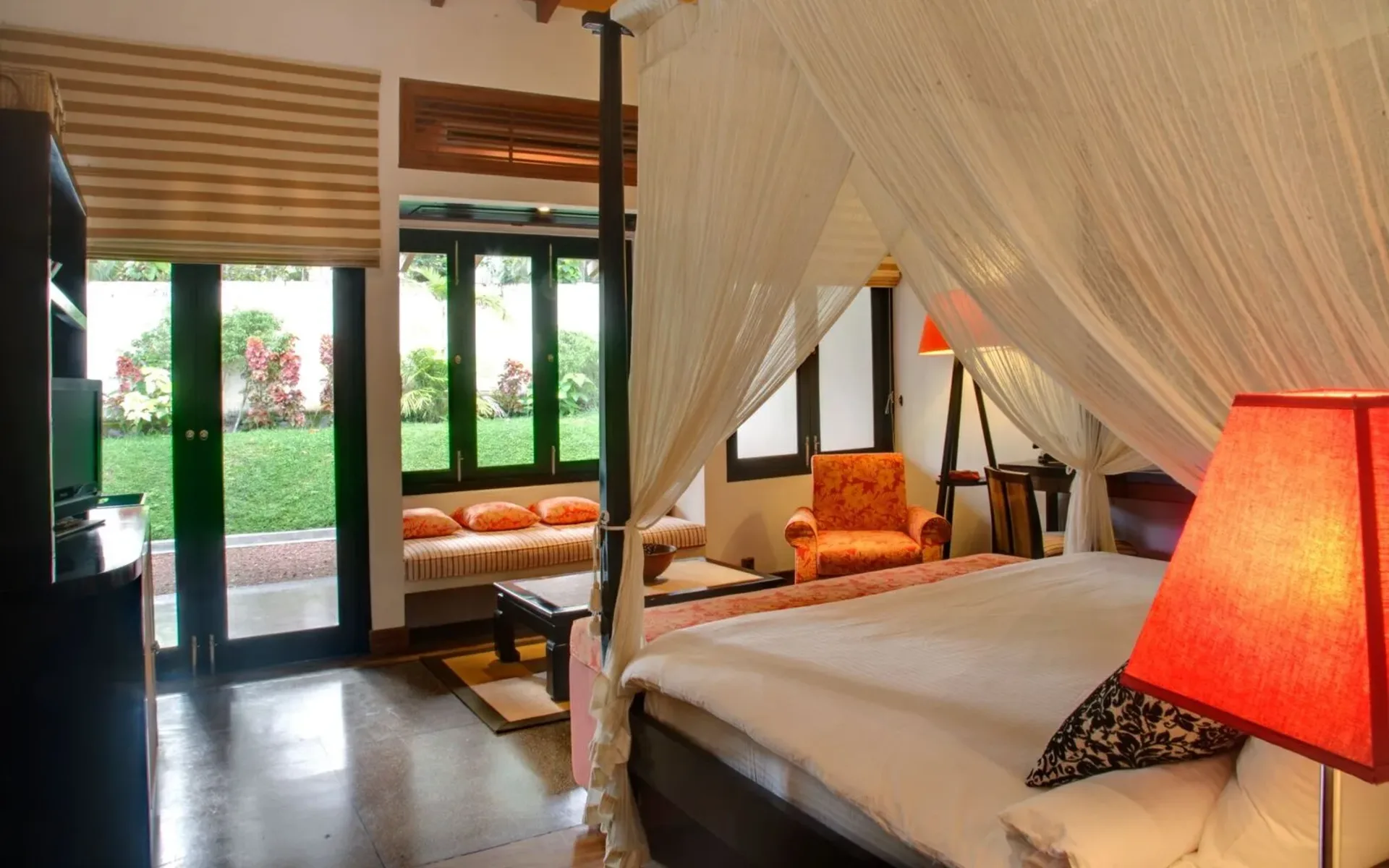 One of the bedrooms in the Wallawwa suites is dressed in comfy furnishings, accented by bright orange tones