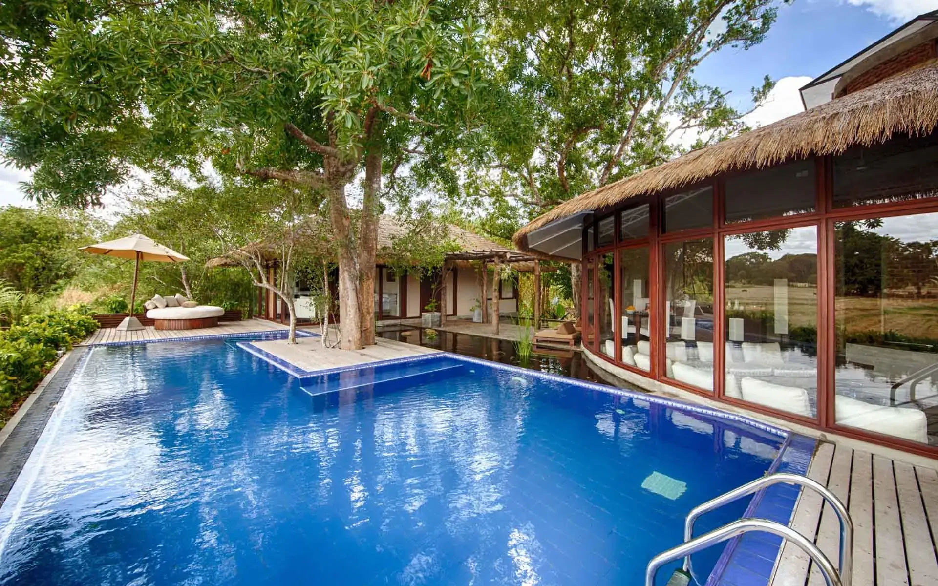 one of the private pools in the Nikawala Villas. It is spacious and shaded by a large tree.