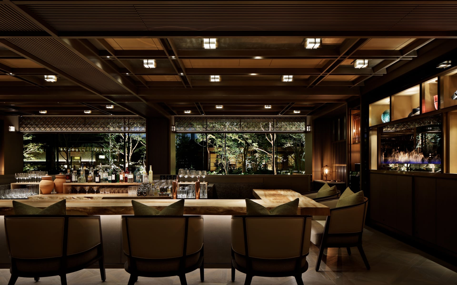 The bar and lounge at The Mitsui has low-lighting, long tables and views into the garden. 