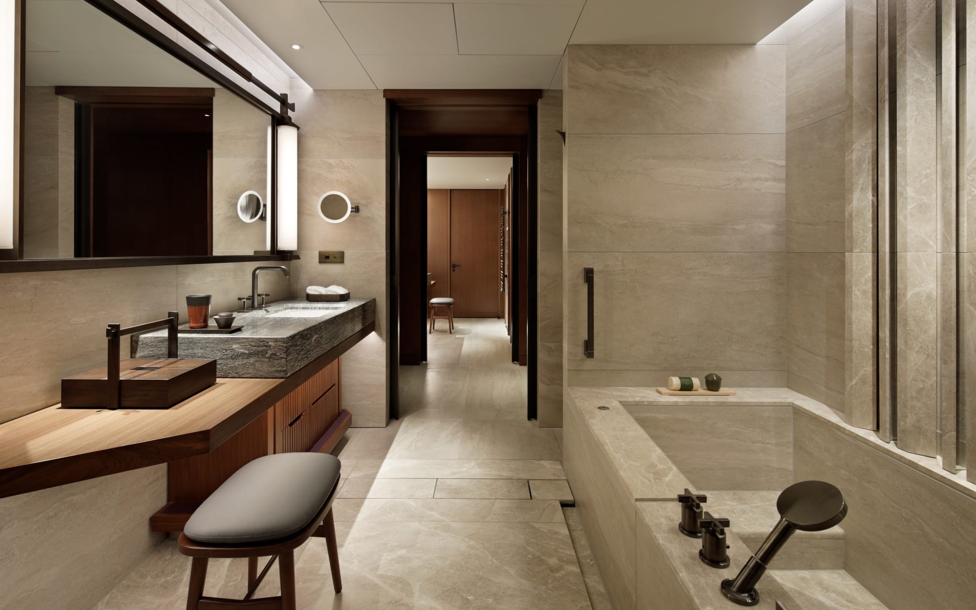 The Mitsui's presidential suite bathroom has a sink, a vanity area with a chair, and an enormous marble bath. 