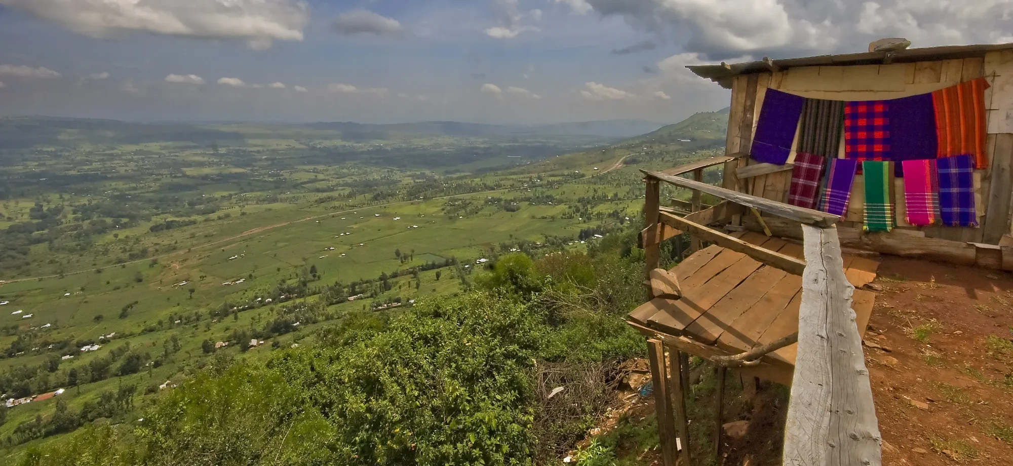 A lookout point gazes over the rolling hills of the Great Rift Valley during a sunny day