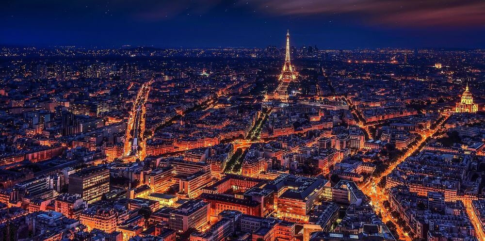 aerial view of Paris and the Eiffel Tower lit up at night