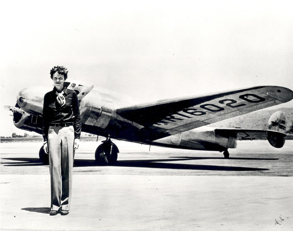 Amelia Earhart female aviator next to plane