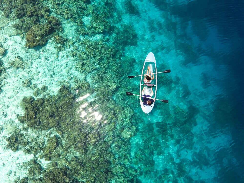 couple kayaking in crystal blue waters