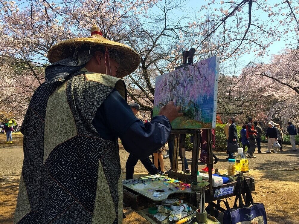 Japanese man painting sakura during cherry blossom viewing season in Japan