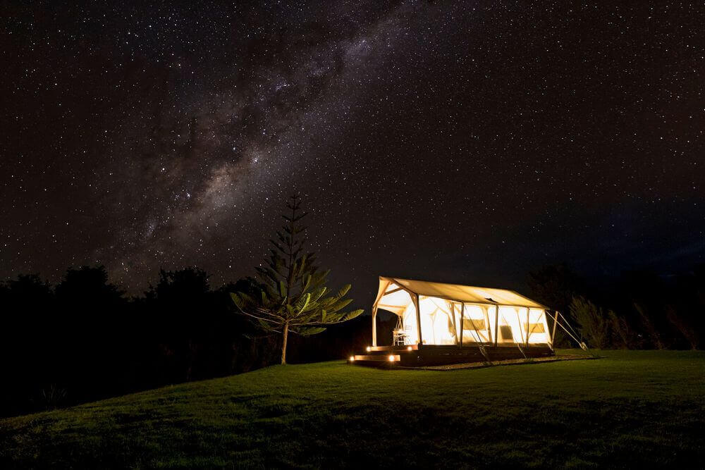 magic cottage luxury camping site lit up beneath the starry sky takou river new zealand