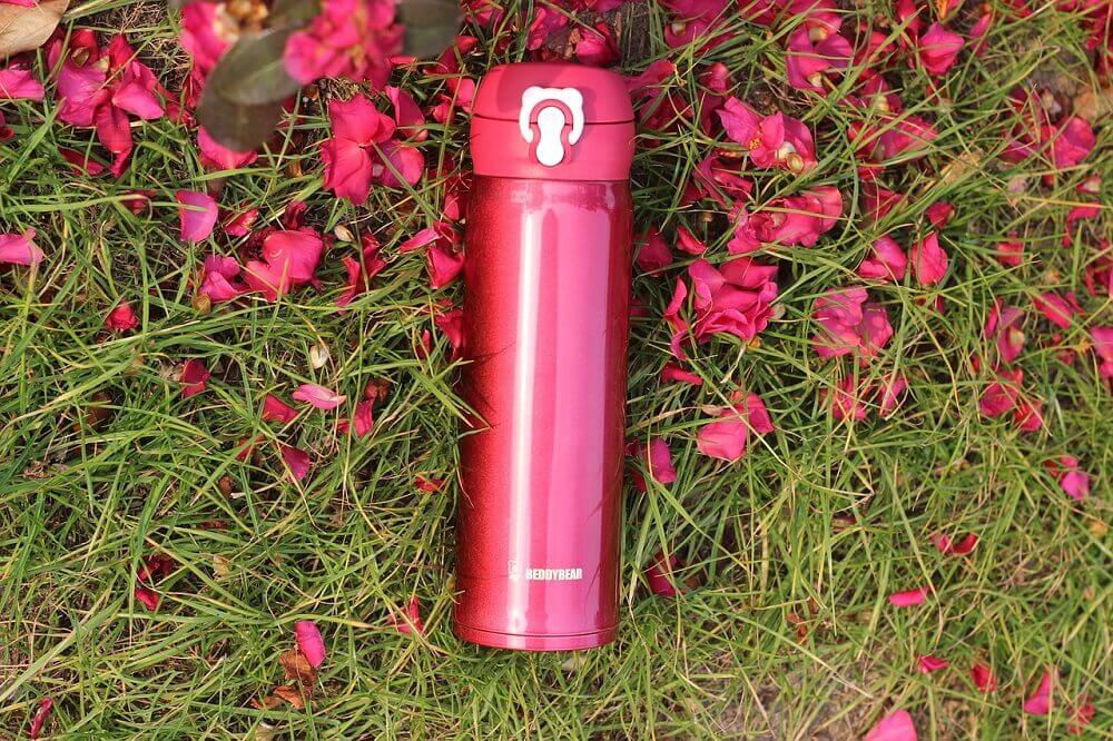 Pink reusable water bottle in grass