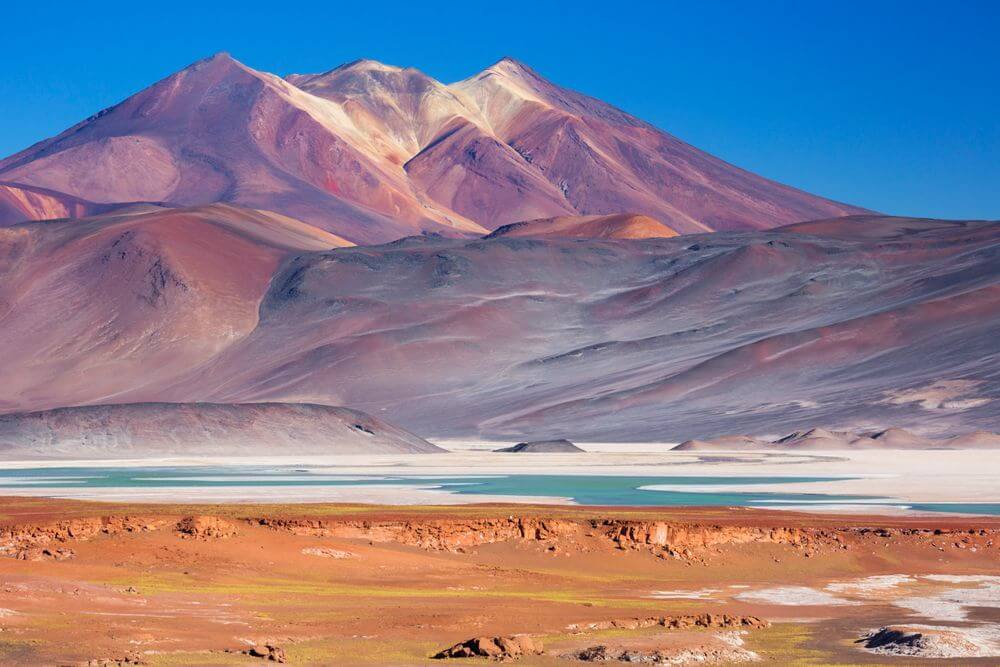 colourful red mountains and dazzling blue lakes in the salt flats of Atacama Desert