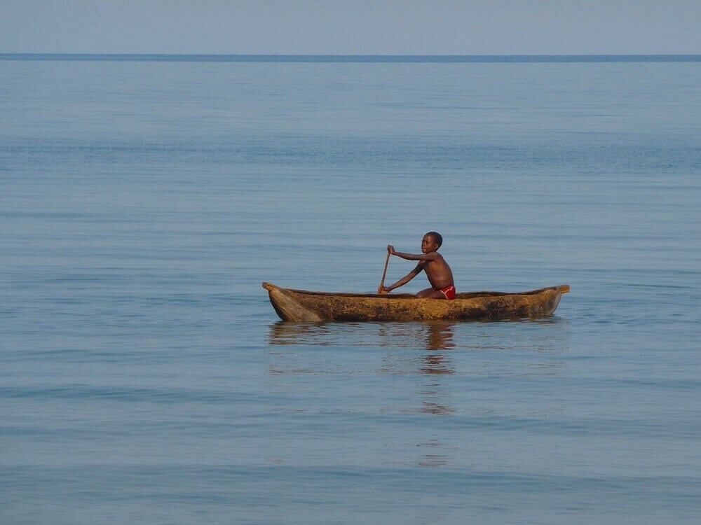 serene_malawi_lake_boy_paddling_boat