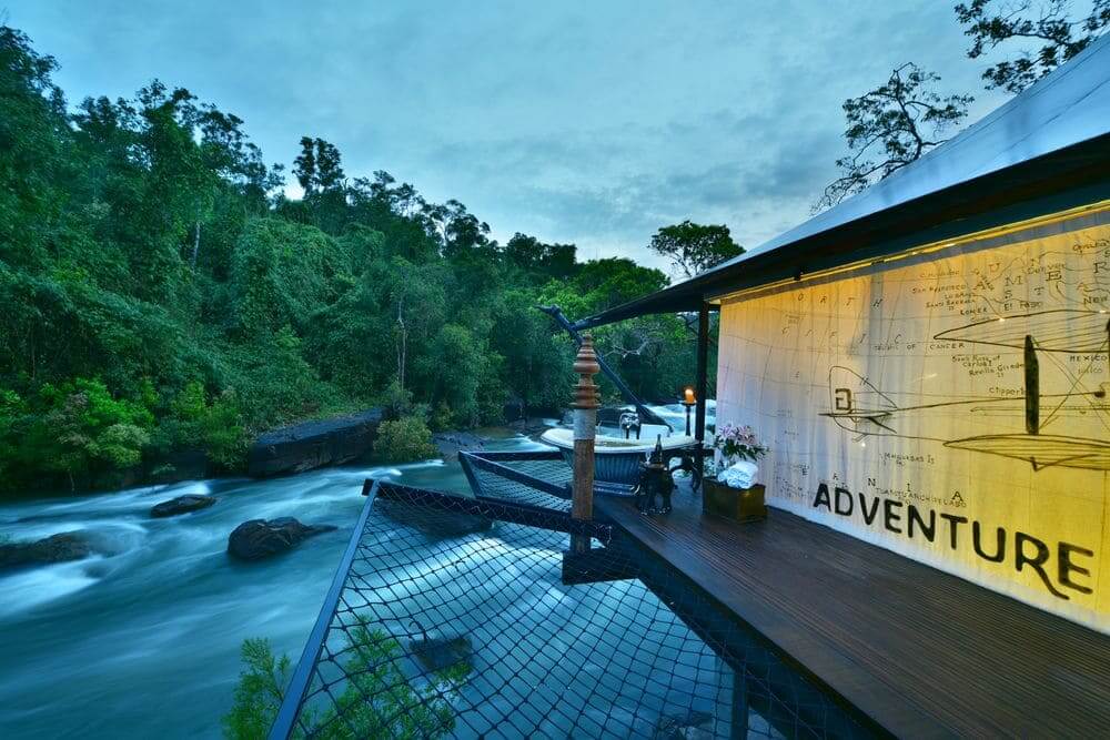 outdoor bathtub perched over the river with adventure mural