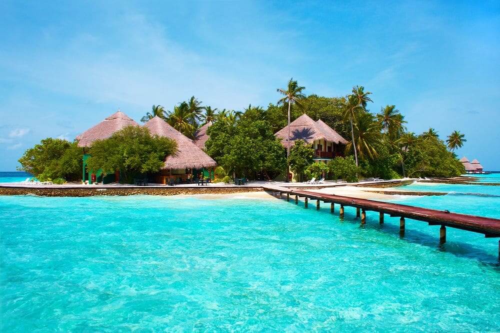 villas on an island surrounded by dazzling water in the maldives