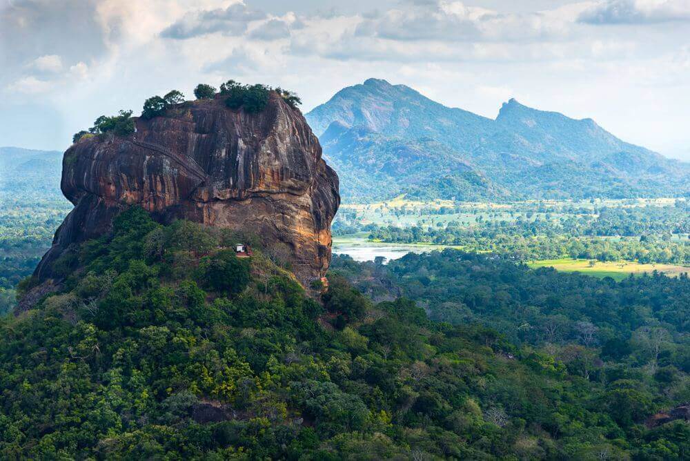 sigiriya lion rock rising through the lush forest in sri lanka