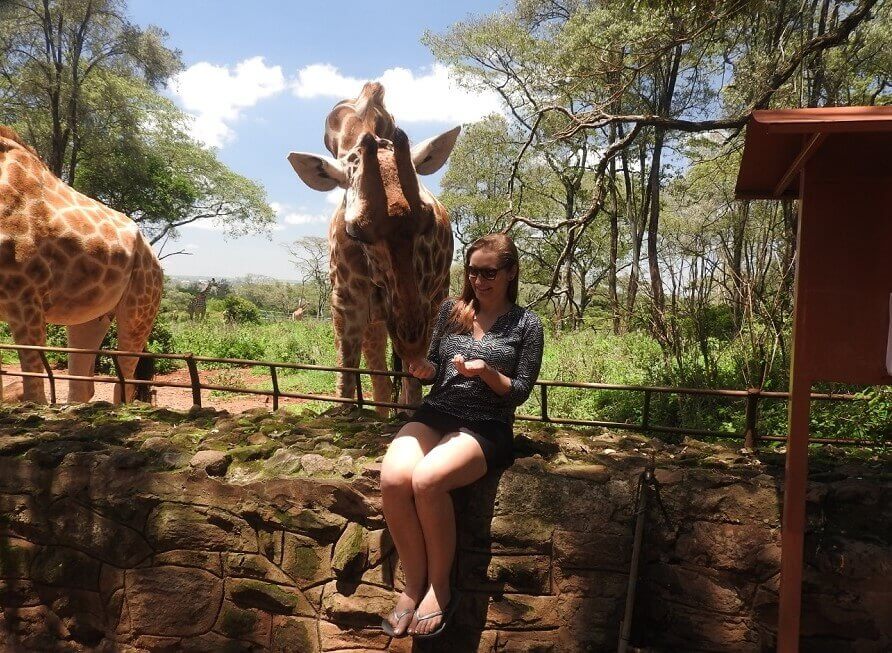 Thea feeding giraffe in Kenya