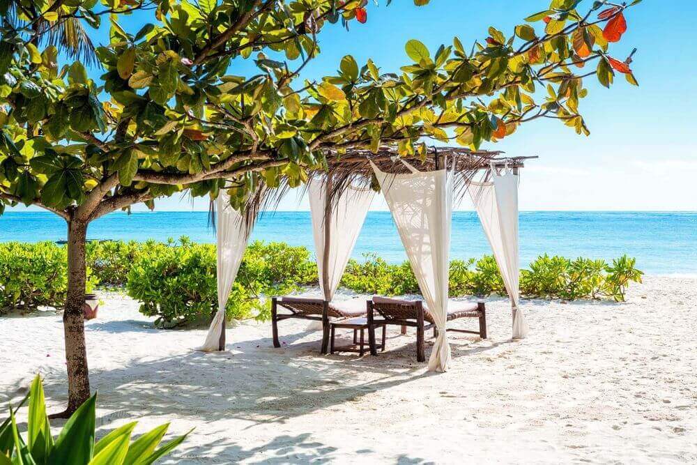 idyllic white sandy beach and day bed in zanzibar