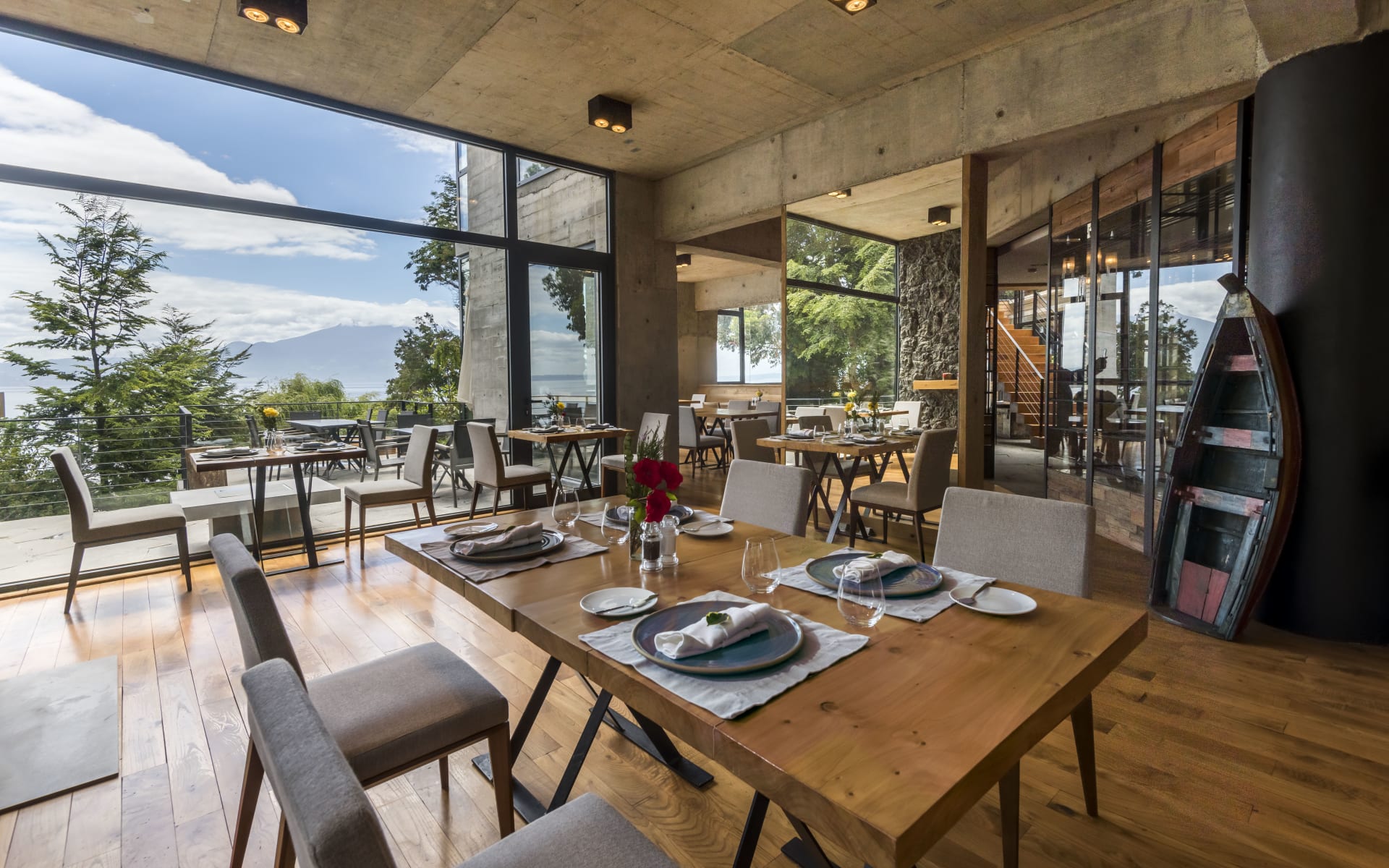 The restaurant at Hotel AWA is designed with wood and floor-to-ceiling windows, overlooking the lake and mountains. 