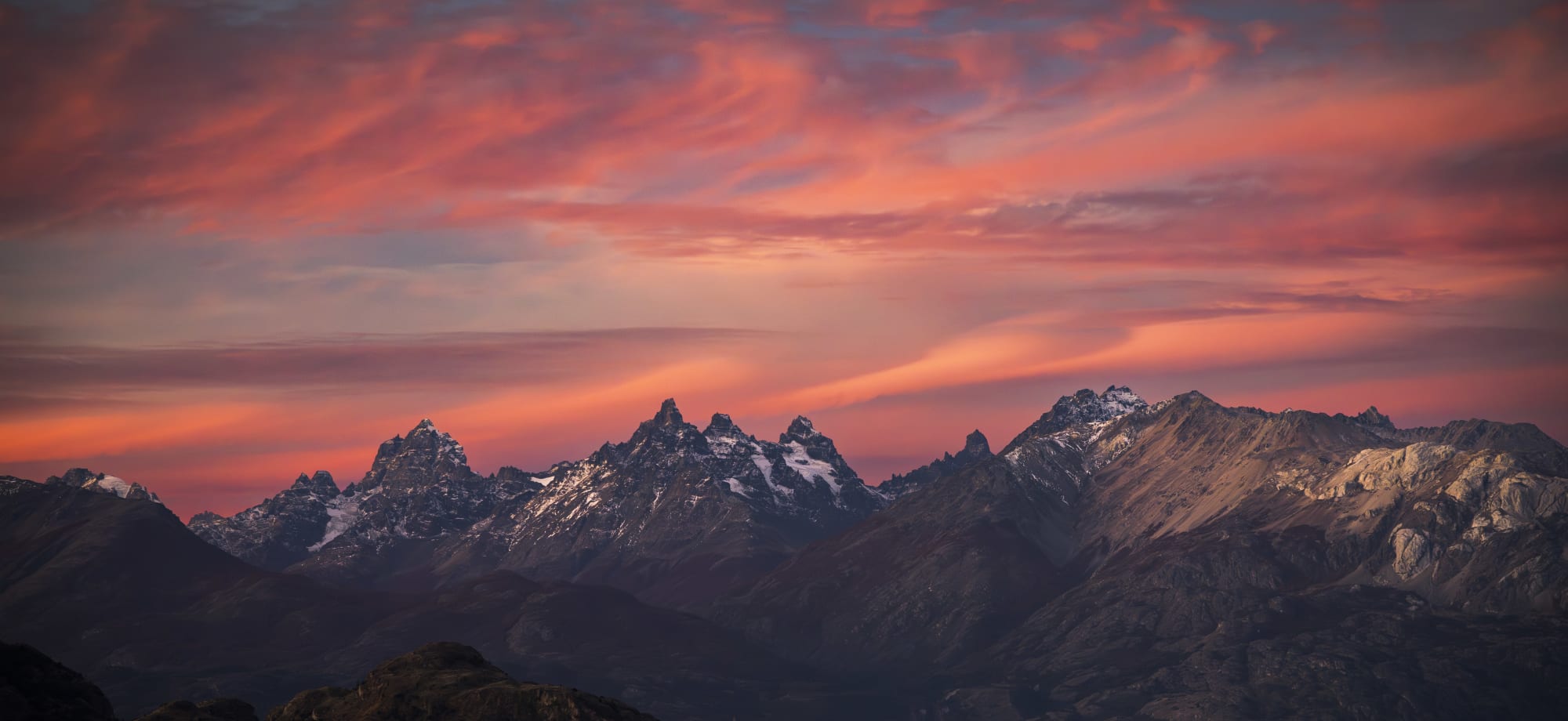 A red sky backs staggering mountains with snow.