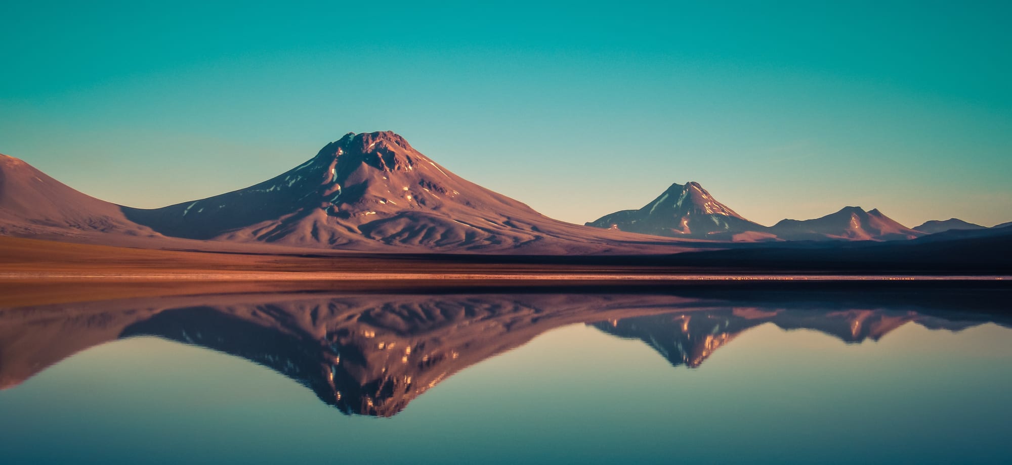 San Pedro de Atacama mountains are reflected into a lake. 